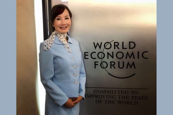 Jane Sun poses in front of a World Economic Forum sign