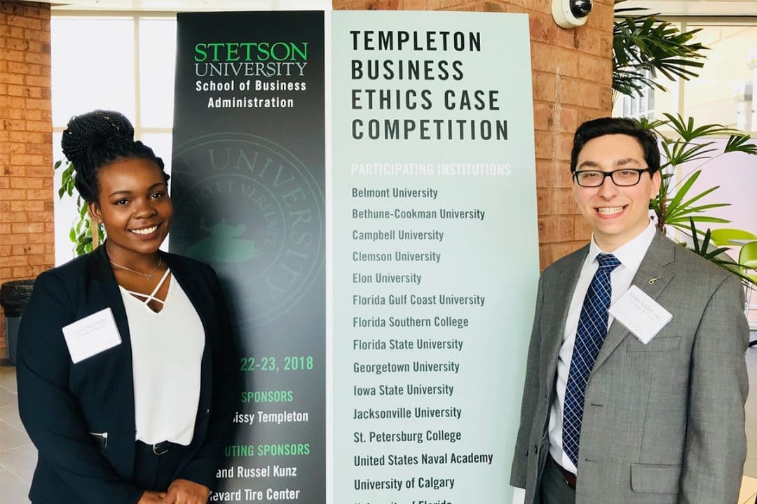 Crystal McDuffy & Justin Schlakman post with a sign for the Templeton Business Ethics Case Competition