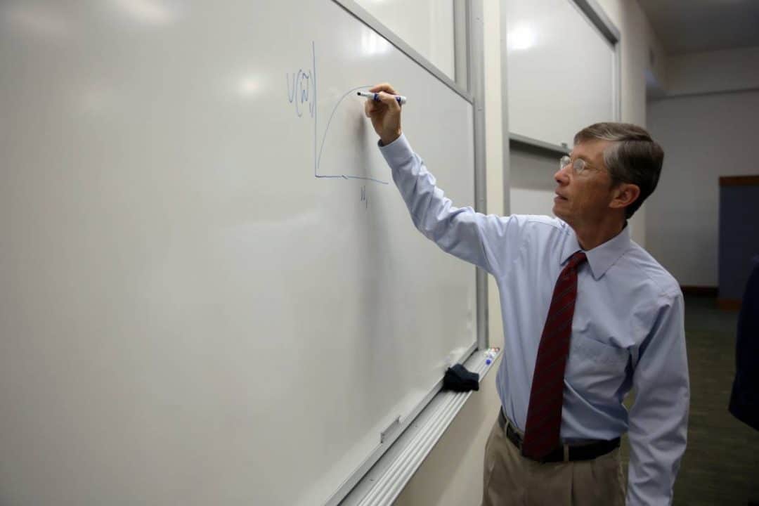 Jay Ritter draws a graph on a whiteboard in a classroom