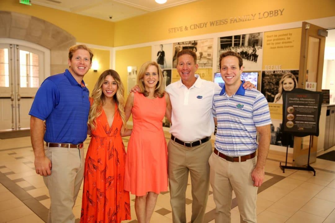 Steve and Cindy Weiss pose with their two sons and daughter in the Steve & Cindy Weiss Family Lobby in Heavener Hall