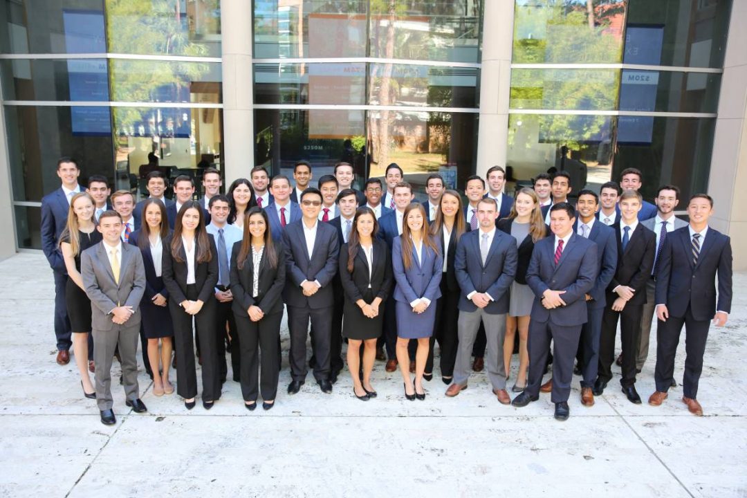 Large group of students in the Gator Student Investment Fund pose for a photo in front of Hough Hall