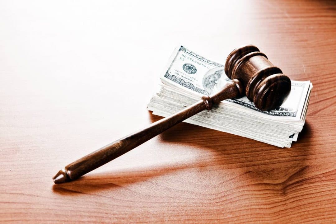Gavel sitting on top of a large stack of money