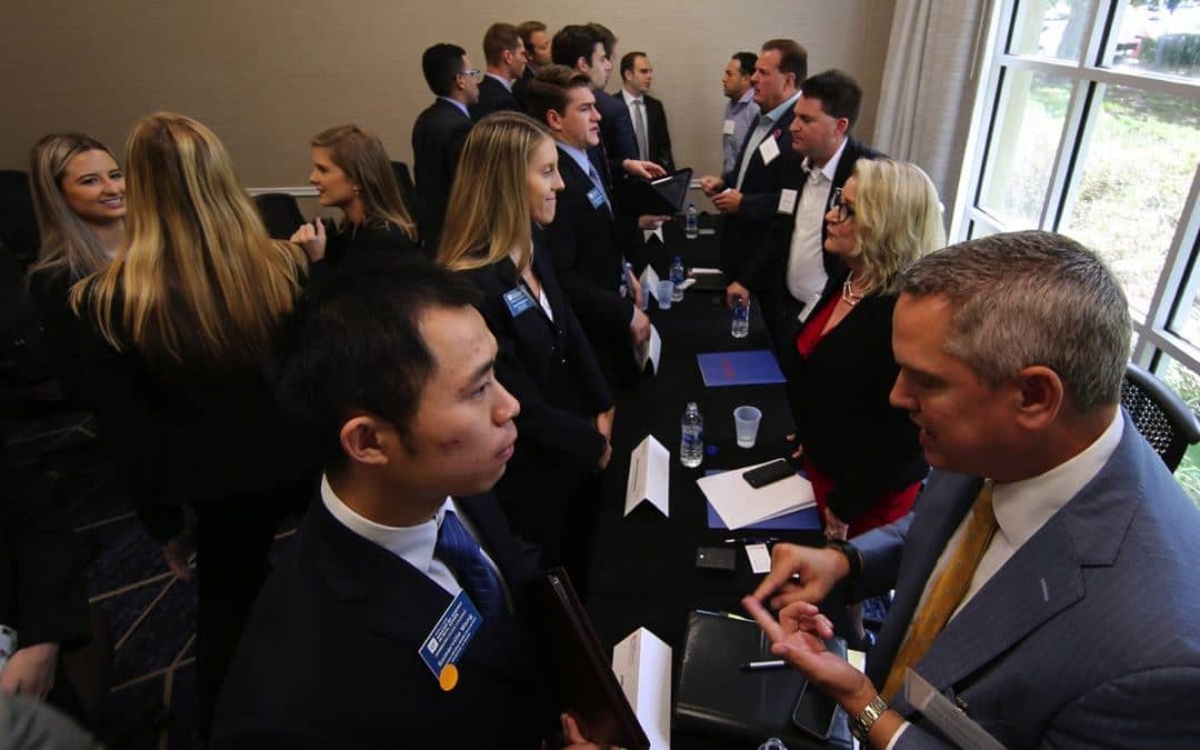 Students in suits talking with company recruiters