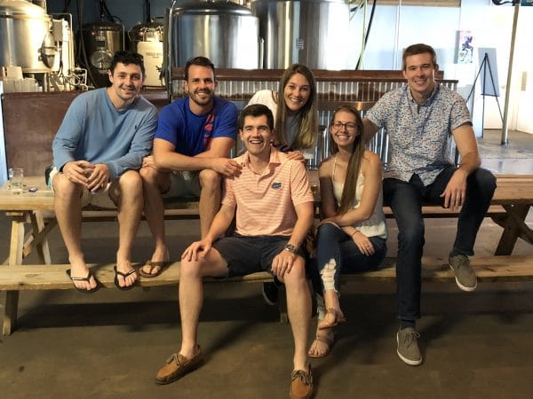 UF MBA Full-Time students sit on picnic tables at a local brewery