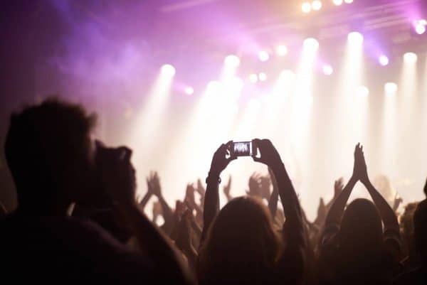 Person standing in a crowd at a concert taking a photo of the stage.