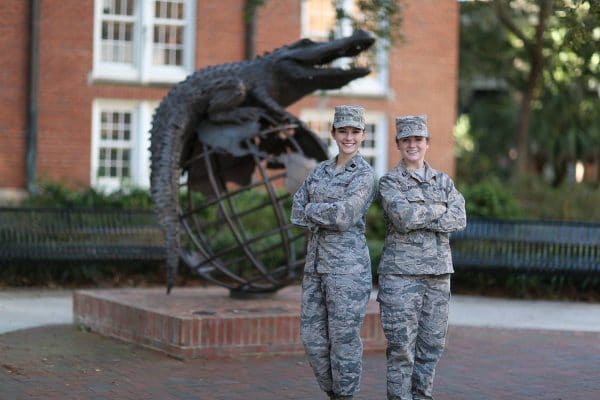 Jasmin Snodgress and Kathryn Eifert stand in front of the Gator Ubiquity Statue