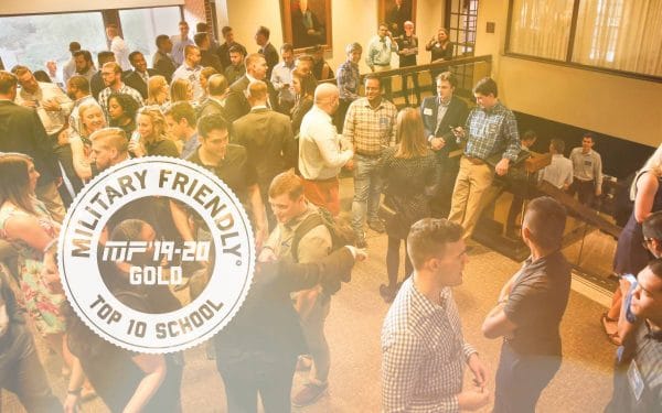 UF MBA students network prior to an event with former Chairman of the Joint Chiefs of Staff General Martin E. Dempsey, U.S. Army, Retired. The military friendly top 10 ranking logo is in the corner of the photo of the students.