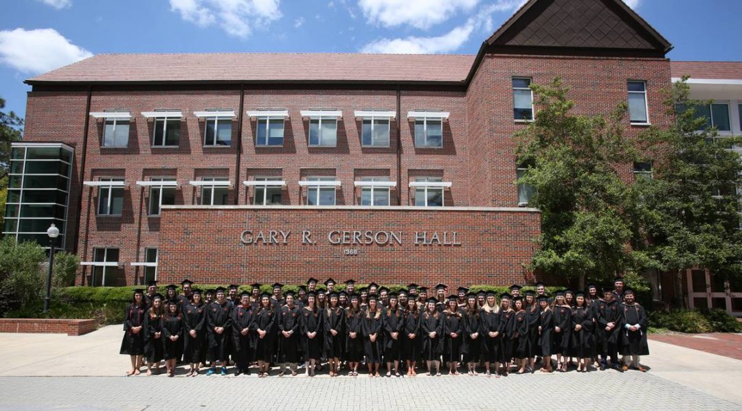 Fisher School of Accounting graduates line up in front of Gerson Hall, where the Fisher School if housed.