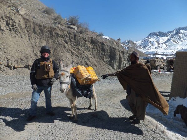 Javier Castano with a donkey packed with supplies next to a local man