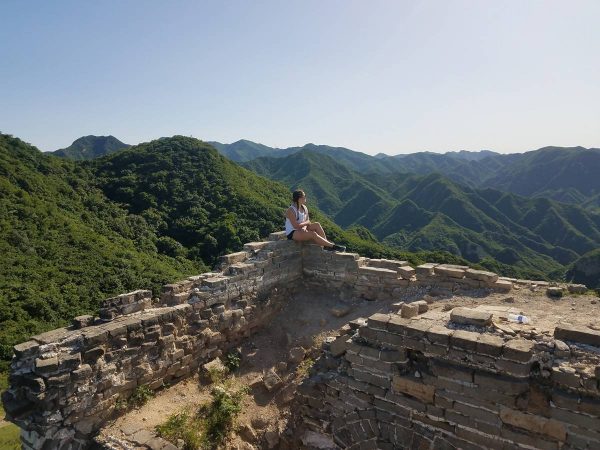 A female student sits on the Great Wall of China
