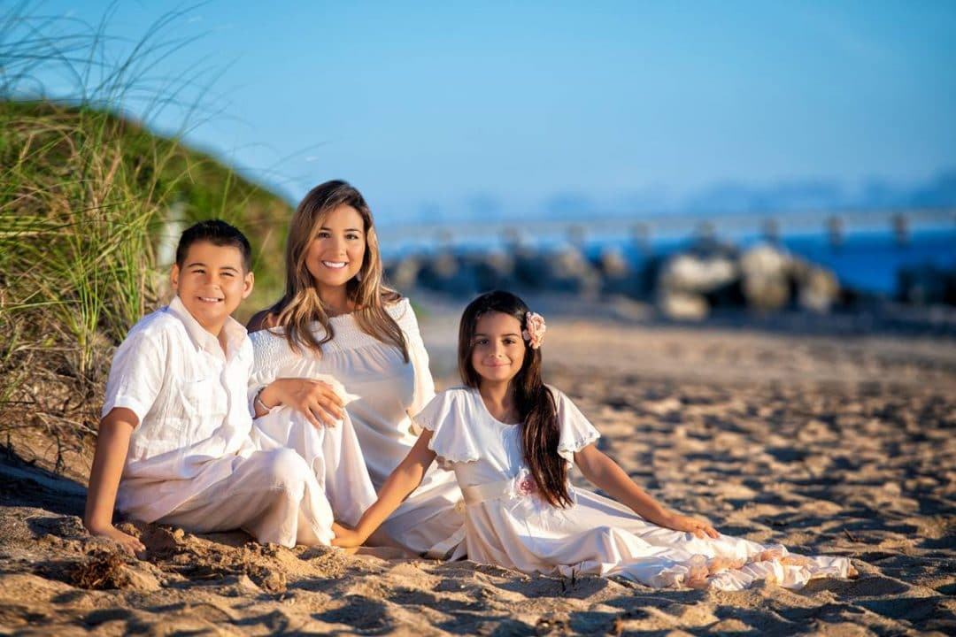 Erika with her Tommy and Gabriela posing for a family photo on the beach.