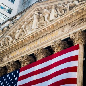 New York Stock Exchange Building on Wall Street with American Flag draped across the front