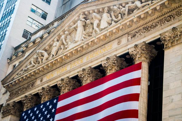 New York Stock Exchange Building on Wall Street with American Flag draped across the front