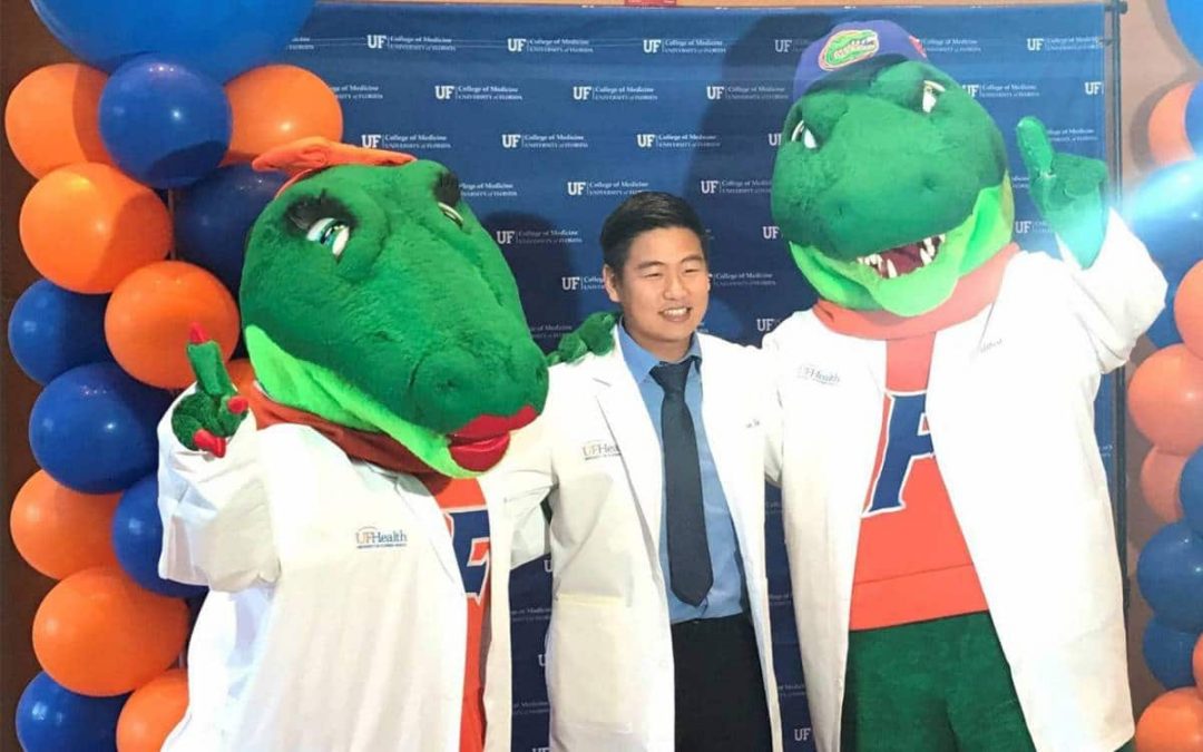 Justin Kim with Albert and Alberta mascots in lab coats