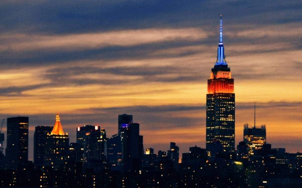 New York City skyline with Empire State Building lit up with orange and blue lights