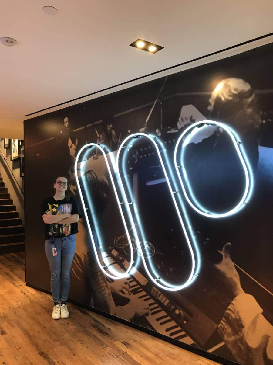 Danielle Gray stands in front of the Warner Music Group logo