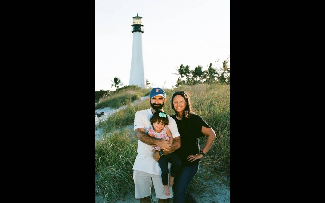 Jessie Wright with his wife and daughter in front of a lighthouse