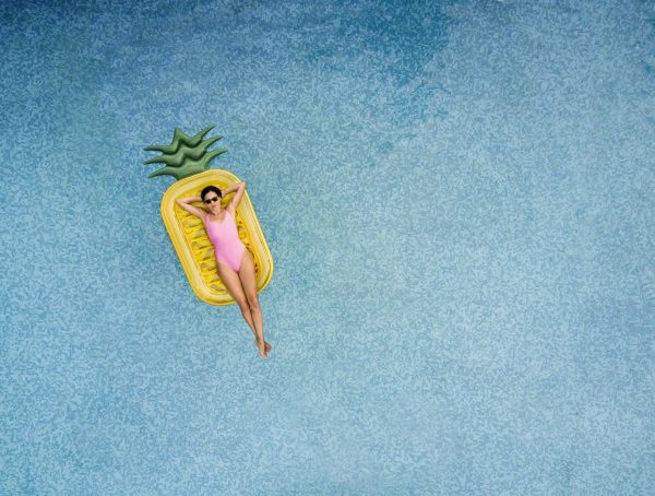 Carefree woman on inflatable pineapple