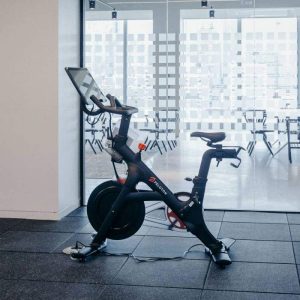 Peloton cardio machine sits in front of a glass window