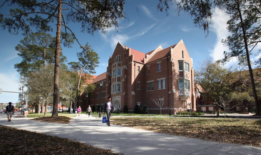Heavener Hall with students walking in front of the building