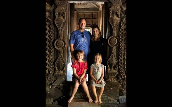 Aaron and Carly Topol pose for a photo in a old building in China with their two daughters