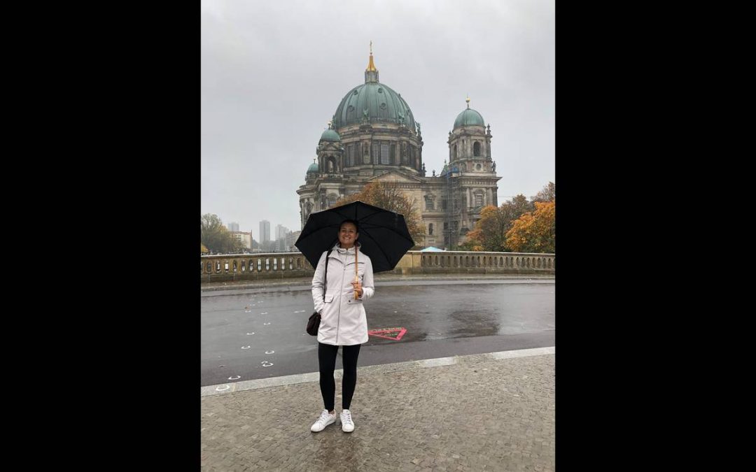 Luiza Duarte stands with an umbrella in historic Berlin