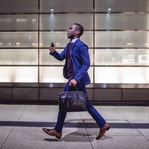 Successful young businessman walking quickly