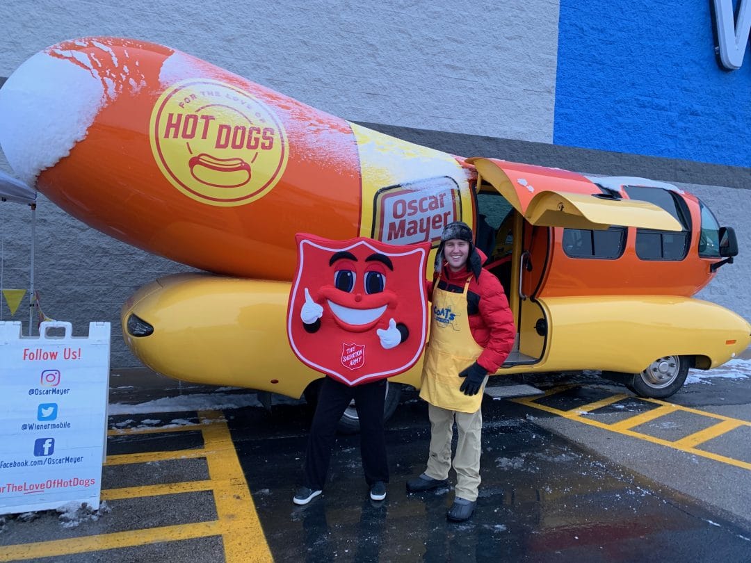 Tyler Peterson stands outside of the Weinermobile, a hotdog shaped bus.