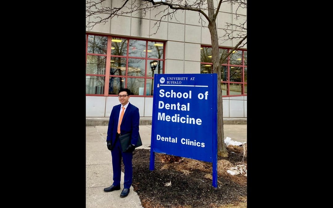 Andy Le stands in front of the University of Buffalo School of Dental Medicine sign