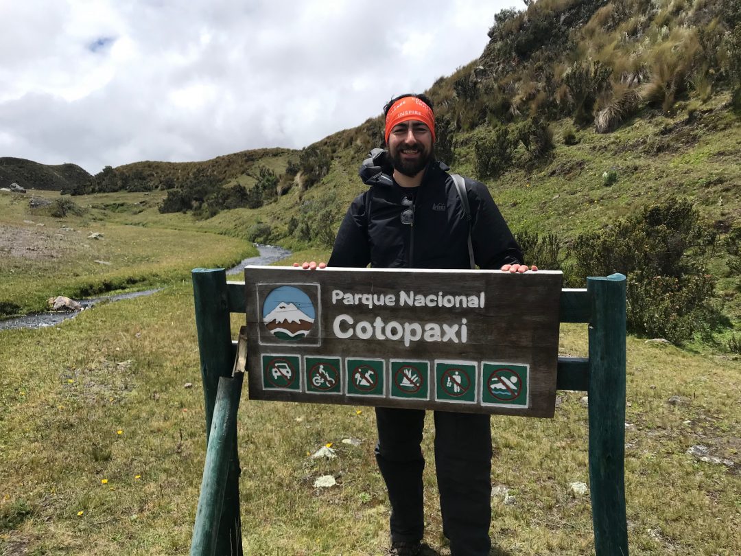 Nick Schumann stands with a sign at Cotopaxi National Park