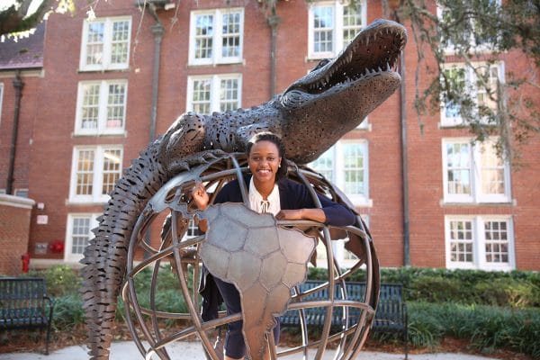 Rachelle Antoine stands inside the globe of the Gator Ubiquity Statue