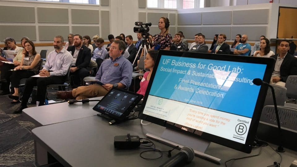 Large group of people listening to a presentation in the Business for Good Lab.