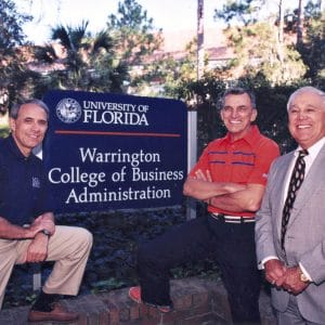 John Kraft, Al Warrington and Robert Lanzillotti pose for a photo in front of the Warrington College of Business sign.