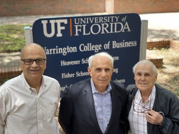 Saby Mitra, John Kraft and Robert Lanzillotti pose for a photo in front of the Warrington College of Business sign.
