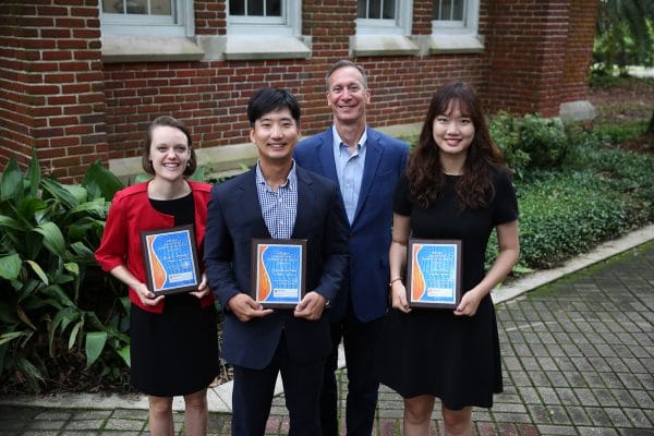 Remy Jennings, Dong Hyun Shin, Jim Parrino and Yiduo Shao pose for a photo with their teaching awards from Warrington.