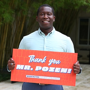 Brandon Harris holds a sign that reads "Thank you, Mr. Pozen."