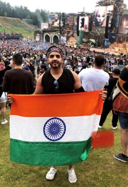Karan Goyal holds India's flag at an outdoor music festival.