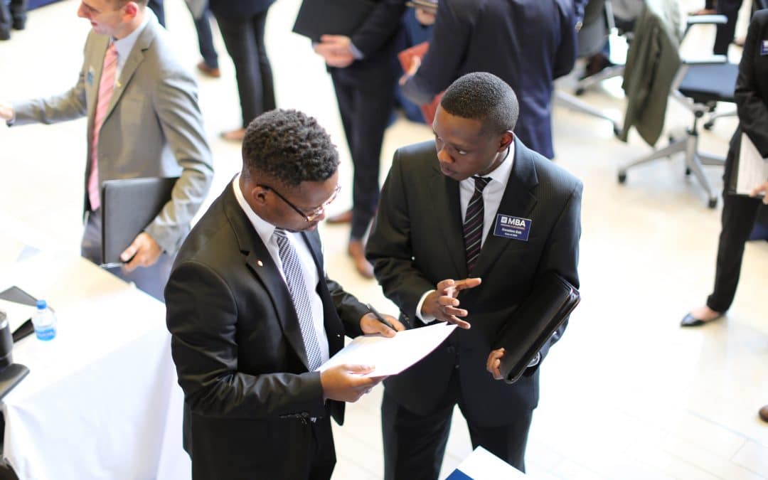Male UF MBA student speaks with a male recruiter at a career event.