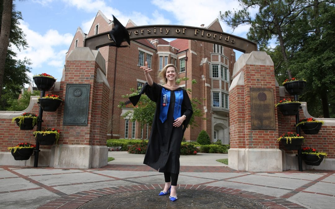 Caroline Beasley tosses her graduation cap in the air in front of the University of Florida archway
