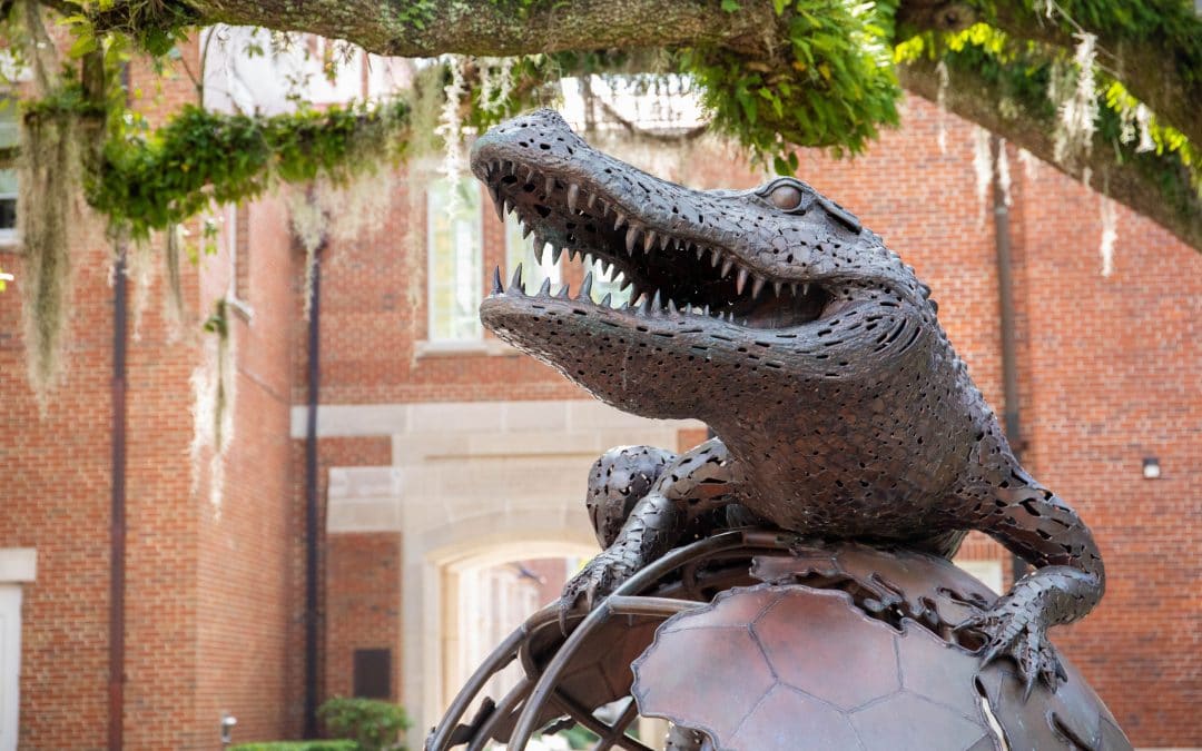 Large bronze statue of an alligator on top of a globe