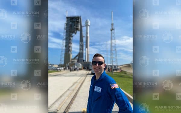 Nathaniel Keyek-Franssen stands in front of the Boeing Starliner on a launchpad at Kennedy Space Center.