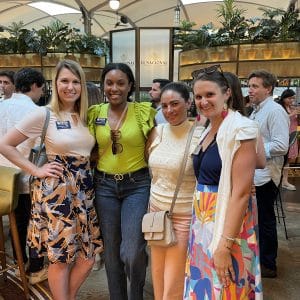 Four women stand together at a networking event