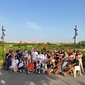 Large group of people pose for a photo in front of a vineyard