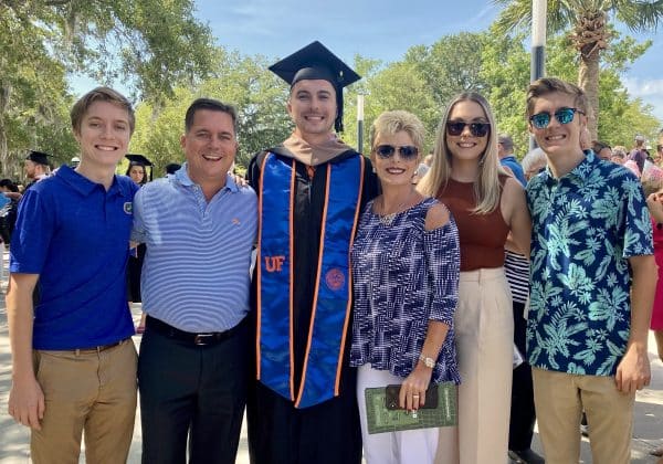 Scotty Exum in UF graduation attire surrounded by his family