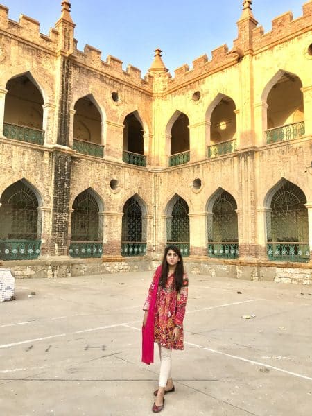 Priyanka Pahuja poses in front of a decorative building.
