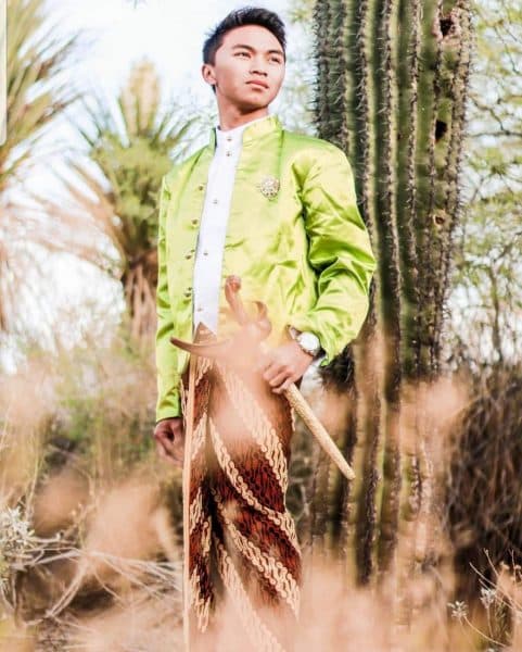Tri Rudiyanto poses in front of a large cactus.