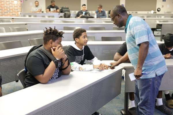 Stephen Asare assists students in the mock accounting class.