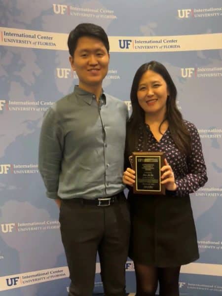 Hae Jin holds her award from the UF International Center and stands with her husband Jaemoon.