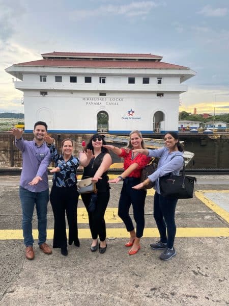 Business students do the Gator Chomp in front of the Panama Canal.