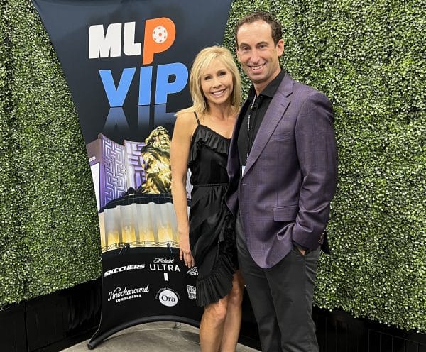 Brian Levine and his wife pose at a sports event.